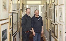 SAM Artistic Director Danny Lacy and Dr. Michael Elliott. Two white man standing in a narrow corridor filled with picture frames.