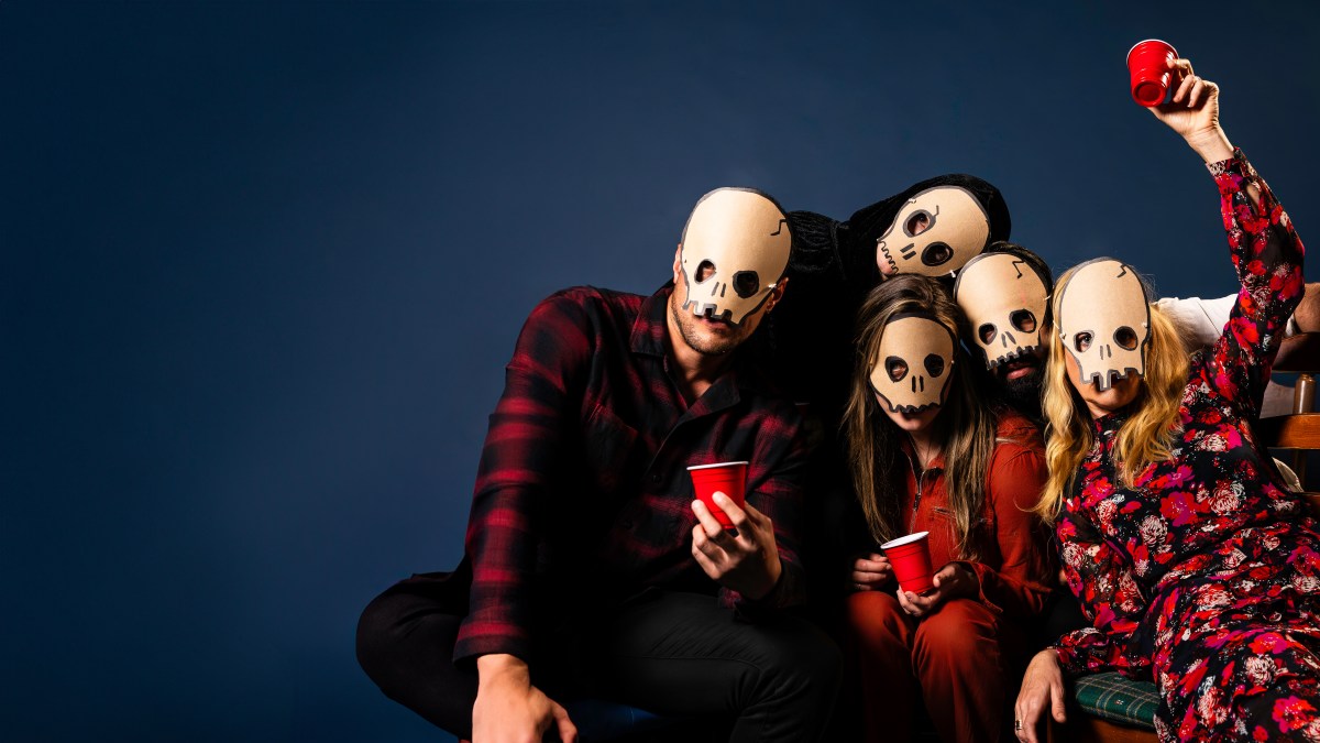 Four people lean on each other against a dark blue backdrop. They are all wearing unnerving white masks. The Comeuppance. Red Stitch