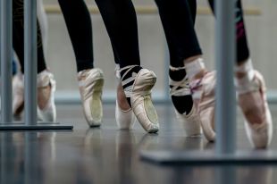 On the Move is ArtsHub's weekly wrap of Australian arts sector appointments. The photo depicts a line of ballerinas training en pointe, showing their feet and shoes in close-up.