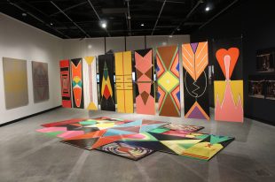 Colourful artwork with different patterns from Yuriyal Bridgeman depicted in panels upright and on the floor.