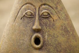 A photo of a sculptured object with a surprise expression on its face.