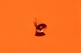 This week’s arts news and trending topics. The image depicts a plastic orange megaphone against an orange background.