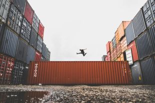 On the Move is ArtsHub's weekly round-up of Australian arts sector appointments and resignations. Photo depicts a parkour jumper mid-leap, framed above a shipping container against a grey sky.