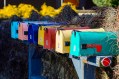 Line of old fashioned colourful letterboxes. Arts news.