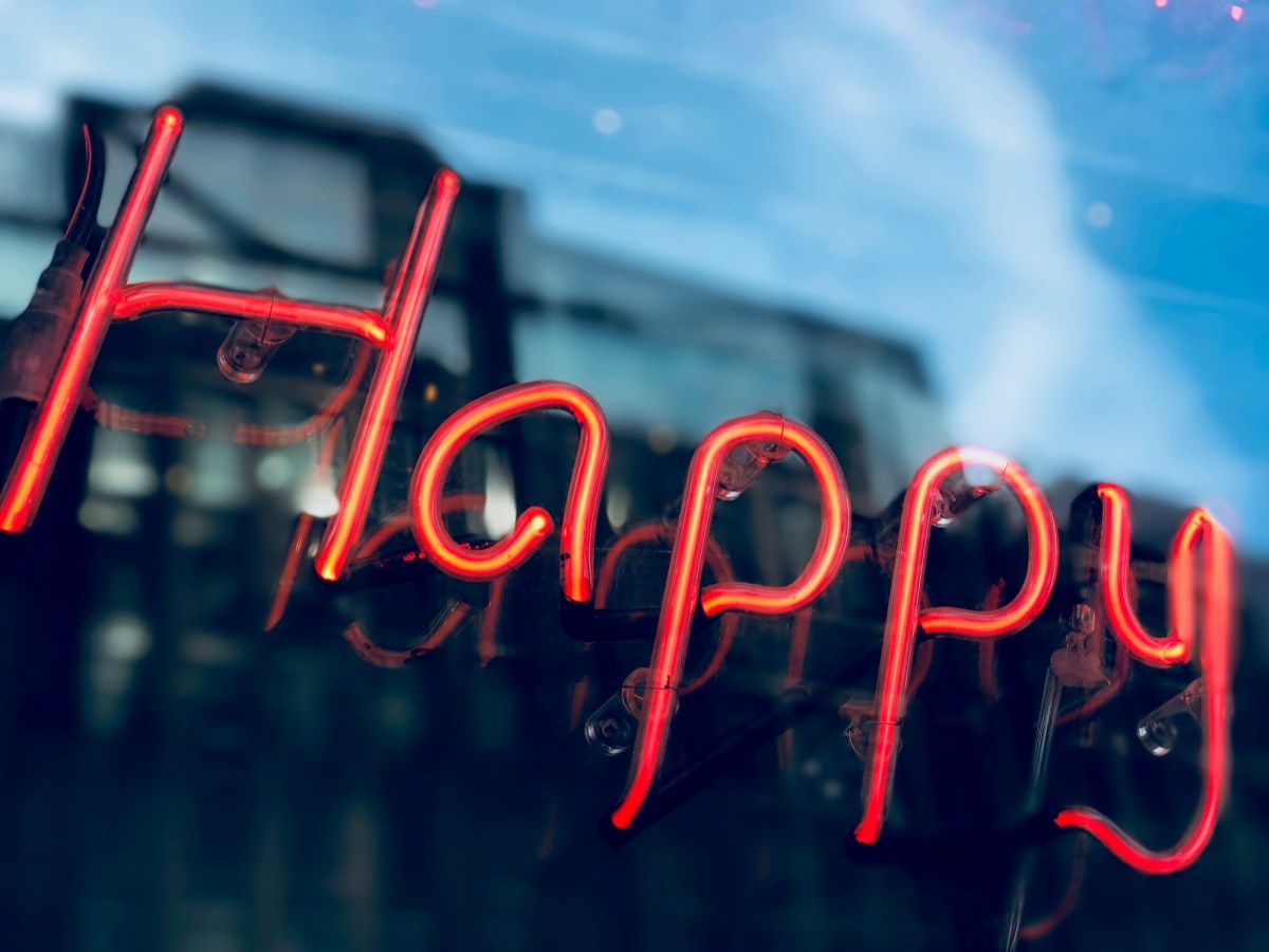 red neon sign saying happy. Wellbeing