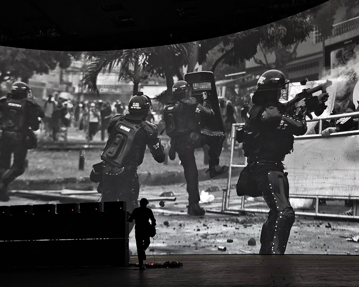 Marco Fusinato, ‘Desastres’ as part of Now or Never 2024. A massive curved screen with photo of police.