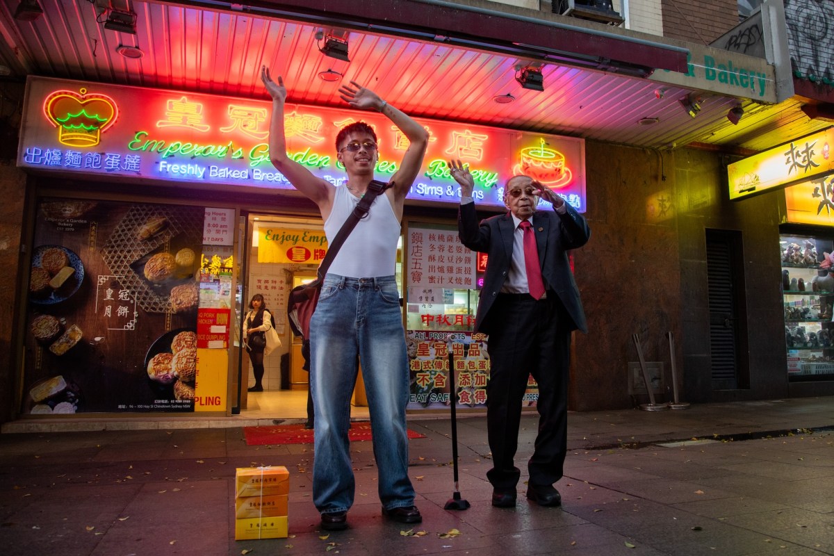 Two people dancing in front of Chinese restaurant with neon lights. Cao Fei