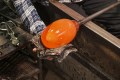 Detail of a glass artist making work with hot glass bubble