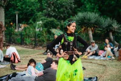 A performer dressed as a fairy in neon green in 'Adventures in Neverland.'