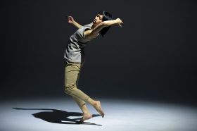 On the Move is ArtsHub's weekly summary of arts sector appointments and departures. The photo depicts a barefoot Asian woman in a dynamic contemporary dance pose. She is barefoot, her back arched, her head tilted back and her arms raised.