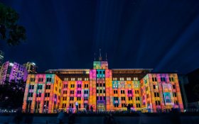 Museum of Contemporary Art Australia at night. A building lit up in pink, blue, purple and orange lights at night.