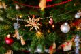 A close up of a Christmas tree, showing baubles and stars.