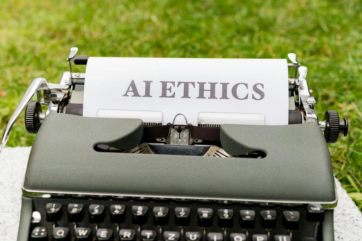 Typewriter with a paper displaying “AI ETHICS” in capital letters.