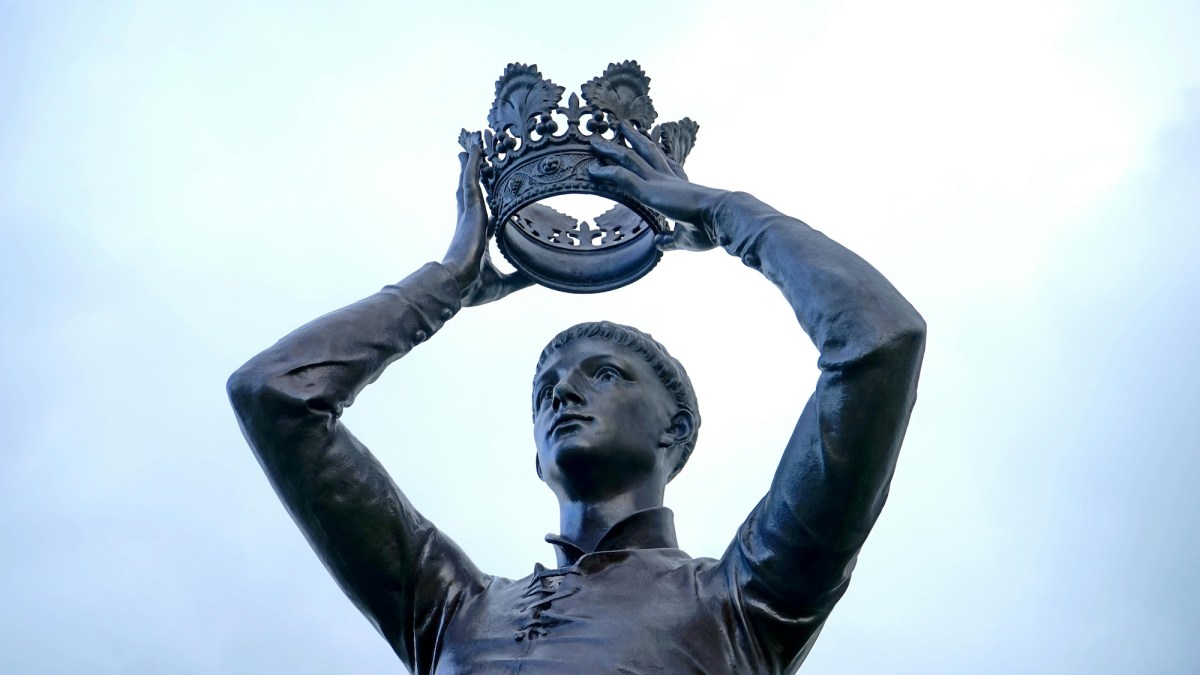 Statue of a man putting a crown on his head. Vale