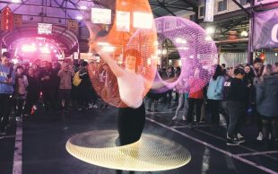 The vast majority of Victorians have or are willing to engage with arts and culture. A woman surrounded by spinning lights inside a market.