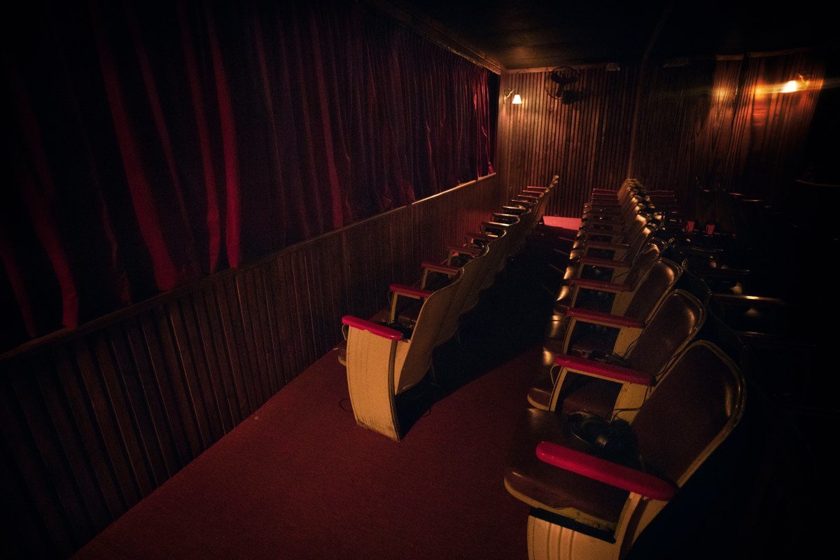 Maroon-coloured seating and curtains resembling those of a theatre.