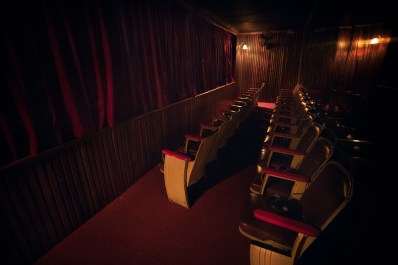 Maroon-coloured seating and curtains resembling those of a theatre.