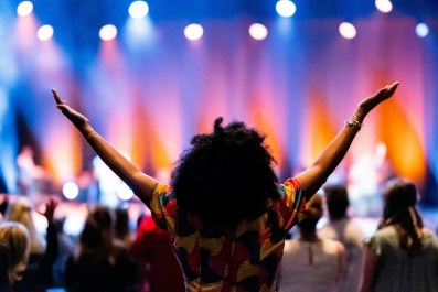 woman with outstretched arts in gratitude in theatre audience.