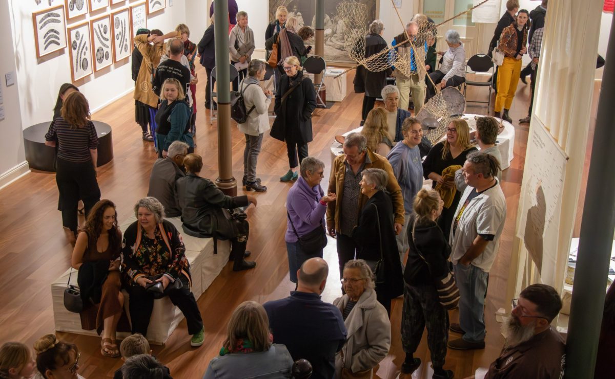 people milling around a gallery space talking and looking at the art. ngaratya NETS Victoria