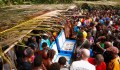 Aerial view of crowd in Papua New Guinea looking into crate with human skulls. Chau Chak Wing Museum repatriation