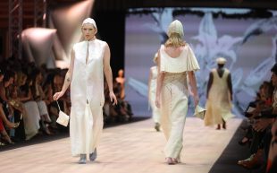 Models on a runway showcasing cream-coloured garments that appear slightly geometric.