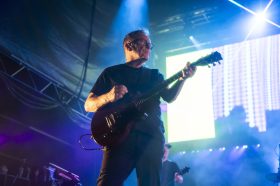 A man on stage with a guitar.