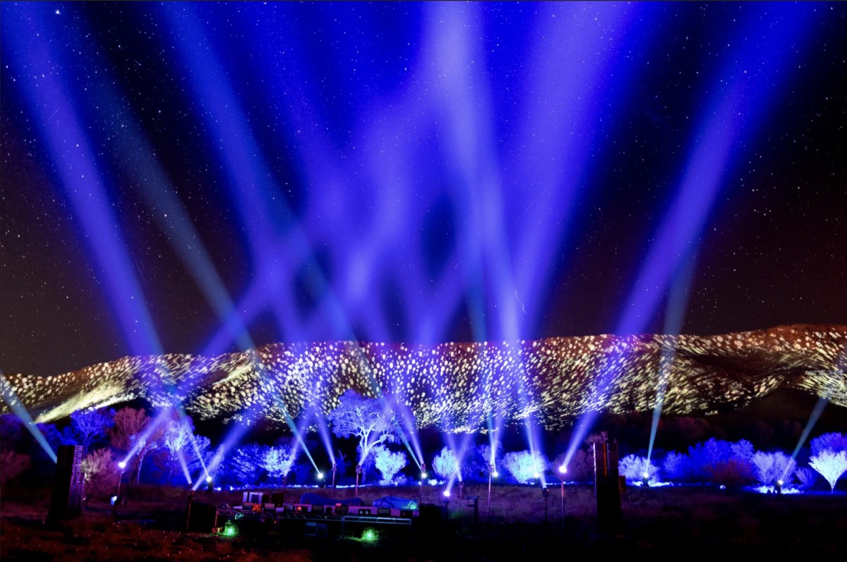 Light projections and light art against mountain range. Parrtjima.