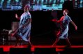 Two women in light white dresses dancing.