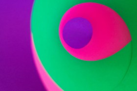 colourful graphic forms in pinks and green creating eye shape. Arts news watch.